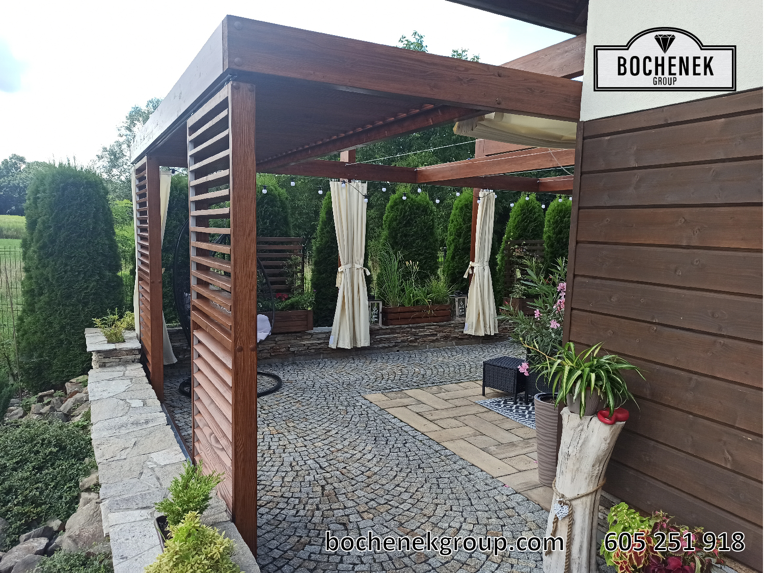 Pergola drewniana Kleopatra z kratownica, zaslonami, stolem i krzeslami w ogrodzie