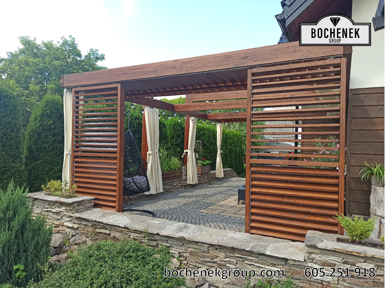 Pergola ogrodowa Kleopatra z drewnianymi lamelami, zywoplotem i kamiennym murkiem