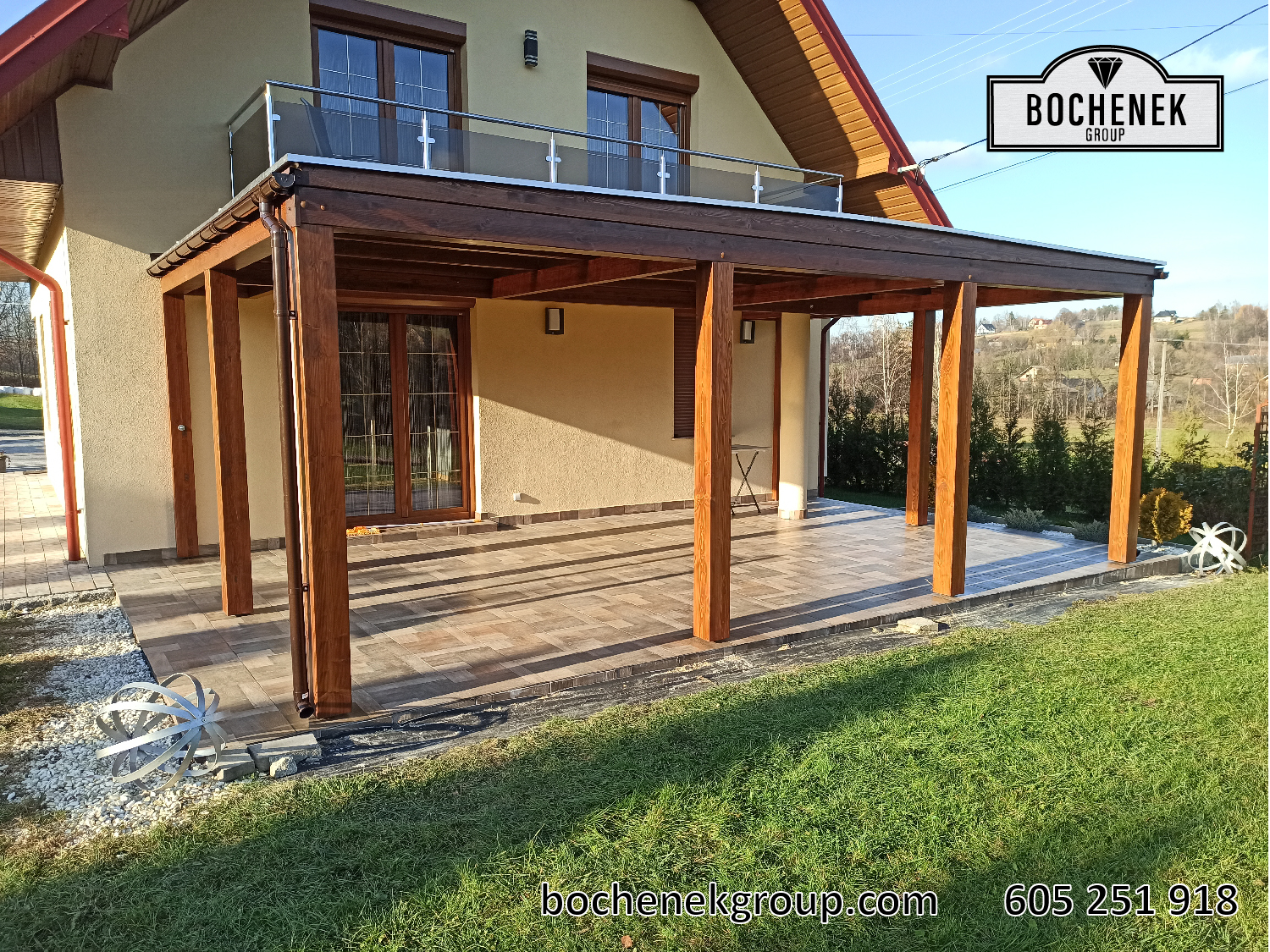 Drewniany taras z pergola, balustrada i brukowanym patio w ogrodzie